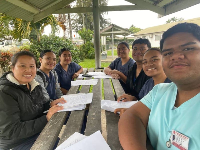Des étudiantes infirmières de YEF Tonga étudiant les Romains autour d’une table de pique-nique